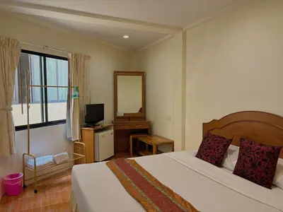 a bedroom with a bed and a desk with a television at Kata View Guest House in Kata Beach