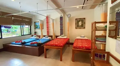a room with two beds and two chairs in it at Kata View Guest House in Kata Beach