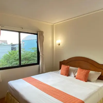 a bedroom with a bed with a large window at Kata View Guest House in Kata Beach