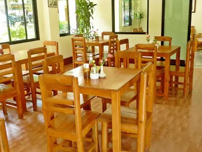a dining room with wooden tables and chairs at Kata View Guest House in Kata Beach