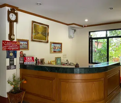 a bar in a restaurant with a clock on the wall at Kata View Guest House in Kata Beach