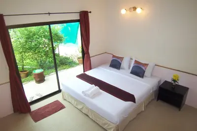 a bedroom with a bed and a large window at Phuket Airport Overnight Hotel in Nai Yang Beach