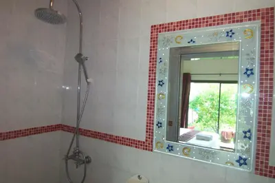 a bathroom with a mirror and a shower at Phuket Airport Overnight Hotel in Nai Yang Beach