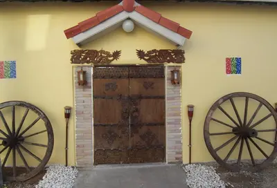 a building with two largeoked wheels in front of a door at Phuket Airport Overnight Hotel in Nai Yang Beach