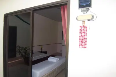 a bathroom with a shower and a toilet in a room at Phuket Airport Overnight Hotel in Nai Yang Beach