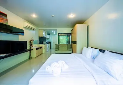 a bedroom with a large white bed with towels on it at The Unity Patong in Patong Beach