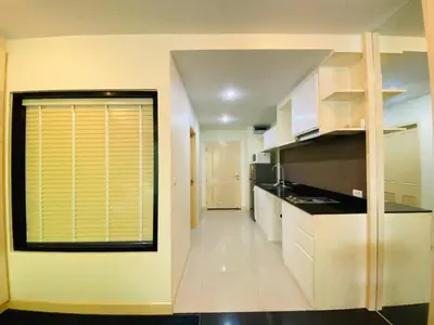 a kitchen with white cabinets and a large window at The Unity Patong in Patong Beach