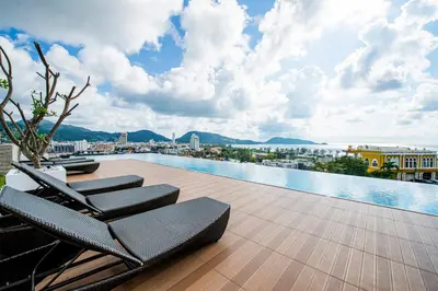 a swimming pool with lounge chairs on a roof at The Unity Patong in Patong Beach