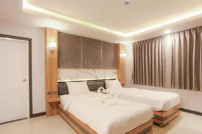 a bedroom with two beds and a window at The Mantra Hotel Kata Noi in Kata Beach