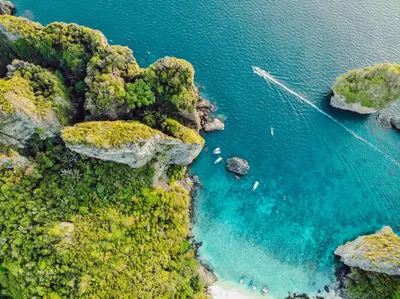 an aerial view of a cove with boats in the water at The Mantra Hotel Kata Noi in Kata Beach