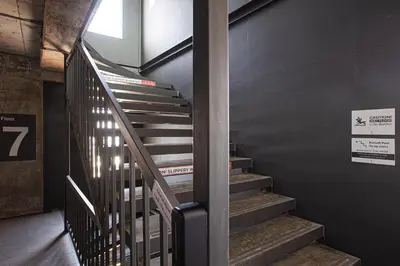 a staircase in a building with a sign on the wall at EcoLoft Hotel - SHA Plus in Phuket Town