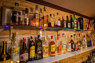 a shelf full of bottles of alcohol on a wall at Pro Andaman Place in Karon Beach