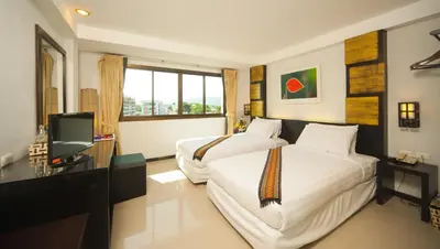 a hotel room with two beds and a television at Crystal Inn in Phuket Town