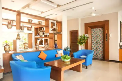 a living room with a blue couch and blue chairs at Crystal Inn in Phuket Town