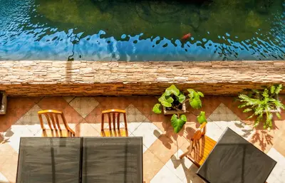 three chairs and a table next to a wall at Crystal Inn in Phuket Town