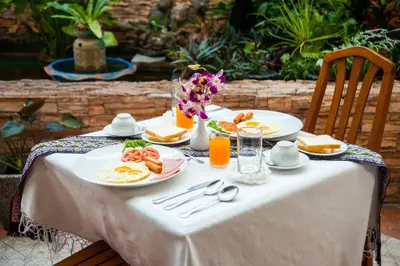 a table with plates of food and orange juice at Crystal Inn in Phuket Town