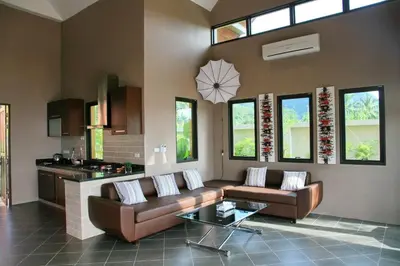a living room with two couches and a table at Tha Lane Bay Villas in Tha Lane Bay