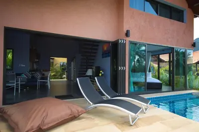 a bedroom with a bed and a swimming pool at Tha Lane Bay Villas in Tha Lane Bay