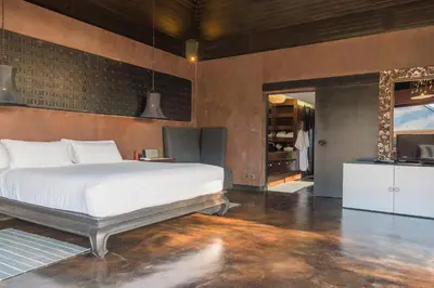 a bedroom with a large bed and a kitchen at Villa Saanti in Natai Beach