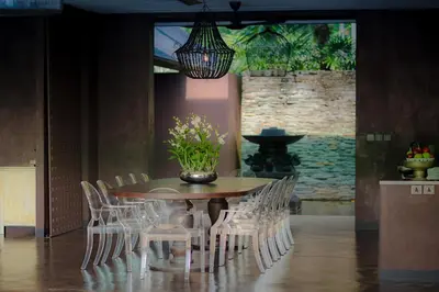 a dining room table with white chairs and a vase of flowers at Villa Saanti in Natai Beach