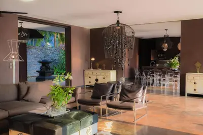 a living room with a couch and a table with chairs at Villa Saanti in Natai Beach