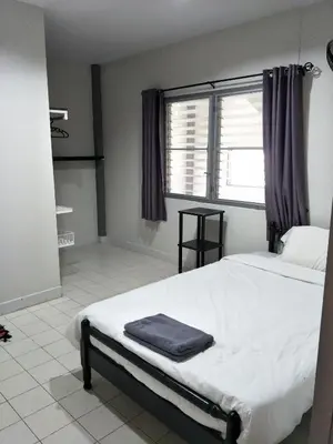 a bedroom with a large white bed with a window at Nit Guest House in Kata Beach