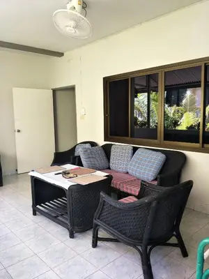 a patio with a couch and chairs and a table at Nit Guest House in Kata Beach