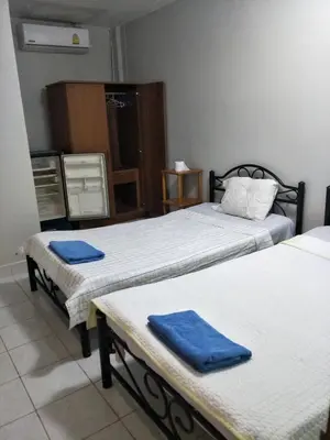 a room with two beds with blue towels on them at Nit Guest House in Kata Beach