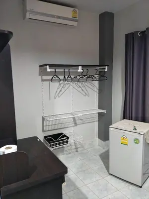 a kitchen with a white refrigerator and a counter at Nit Guest House in Kata Beach