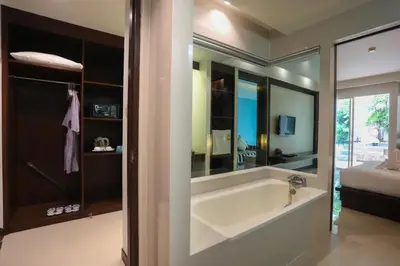 a bathroom with a bath tub with a mirror at A2 Pool Resort - SHA Plus in Phuket Town