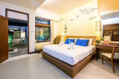 a bedroom with a large bed and a desk at A2 Pool Resort - SHA Plus in Phuket Town