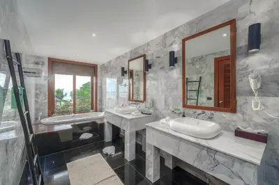 a bathroom with two sinks and two mirrors at Baan Phu Prana Boutique Villa in Surin Beach