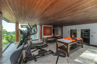 a fitness room with a gym with a treadmill at Baan Phu Prana Boutique Villa in Surin Beach