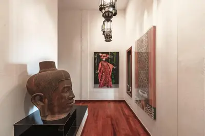 a museum exhibit with a statue and a woman in a dress at Baan Phu Prana Boutique Villa in Surin Beach