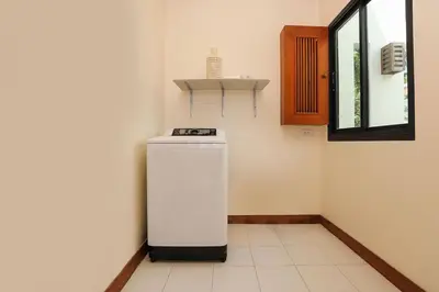 a small refrigerator in a room with a window at Tropical Living at 3BR Pool Villa Bianca, Baan Bua Luxury Estate, Nai Harn Beach in Rawai Beach
