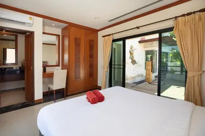 a bedroom with a large white bed and a bathroom at Tropical Living at 3BR Pool Villa Bianca, Baan Bua Luxury Estate, Nai Harn Beach in Rawai Beach