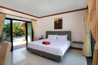 a bedroom with a large bed and a balcony at Tropical Living at 3BR Pool Villa Bianca, Baan Bua Luxury Estate, Nai Harn Beach in Rawai Beach