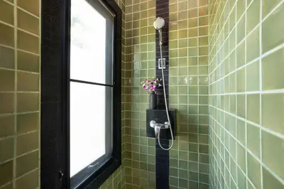 a shower in a green tiled bathroom with a window at Tropical Living at 3BR Pool Villa Bianca, Baan Bua Luxury Estate, Nai Harn Beach in Rawai Beach