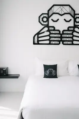 a white bedroom with a bed and a black and white picture at Blu Monkey Phi Phi Island in Phi Phi Don
