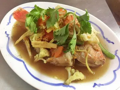 a plate of food with meat and vegetables and sauce at Krabi Villa Phu Khao Private Resort in Klong Muang Beach