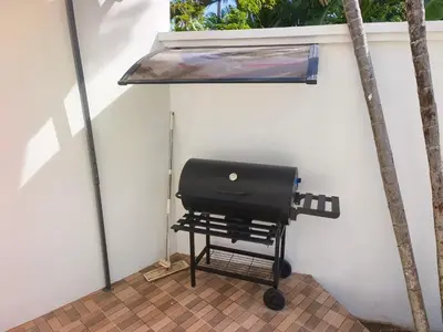 a bbq grill on a patio next to a wall at Thai family rawai Swimming pool villa Hotel in Rawai Beach