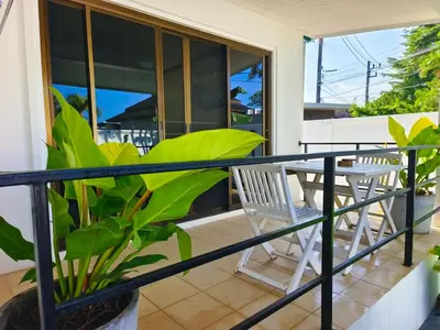 a balcony with a table and chairs and plants at Thai family rawai Swimming pool villa Hotel in Rawai Beach