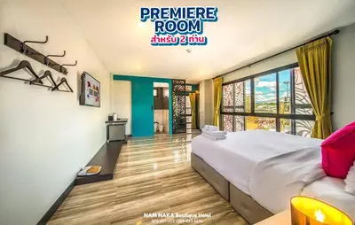 a bedroom with a large bed and a large window at Nam Naka Boutique Hotel - SHA Plus in Phuket Town