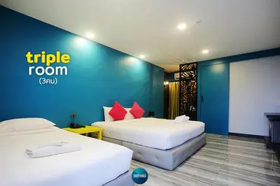 a hotel room with two beds and a blue wall at Nam Naka Boutique Hotel - SHA Plus in Phuket Town