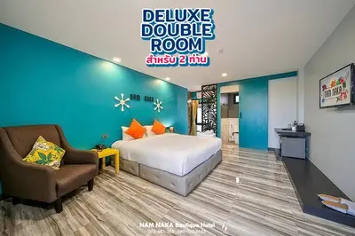 a bedroom with a bed and a couch and a chair at Nam Naka Boutique Hotel - SHA Plus in Phuket Town