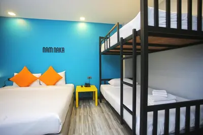 a bedroom with two bunk beds and a blue wall at Nam Naka Boutique Hotel - SHA Plus in Phuket Town
