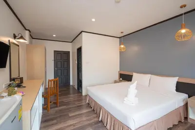 a bedroom with a large white bed and a desk at SB Living Place Hotel Phuket Town in Phuket Town