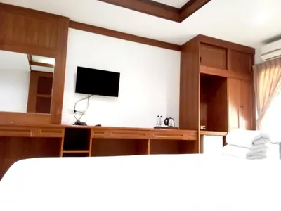 a room with a flat screen tv and a desk with a television at SB Living Place Hotel Phuket Town in Phuket Town
