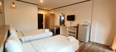 a hotel room with two beds and a desk at SB Living Place Hotel Phuket Town in Phuket Town