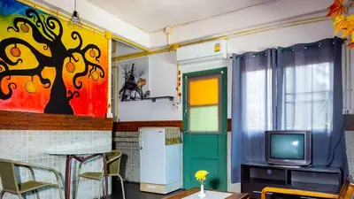 a room with a refrigerator and a tv in it at Sabina Guesthouse Kamala in Kamala Beach